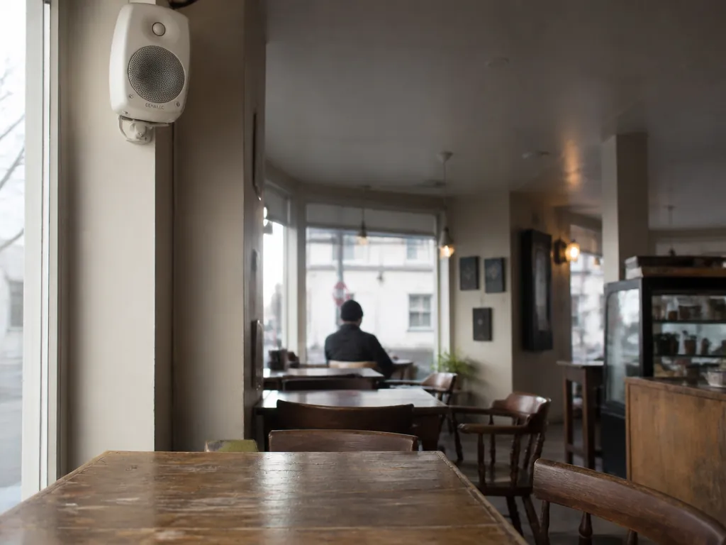 A nearly empty independent coffee shop on a weekday afternoon, shot from a corner…
